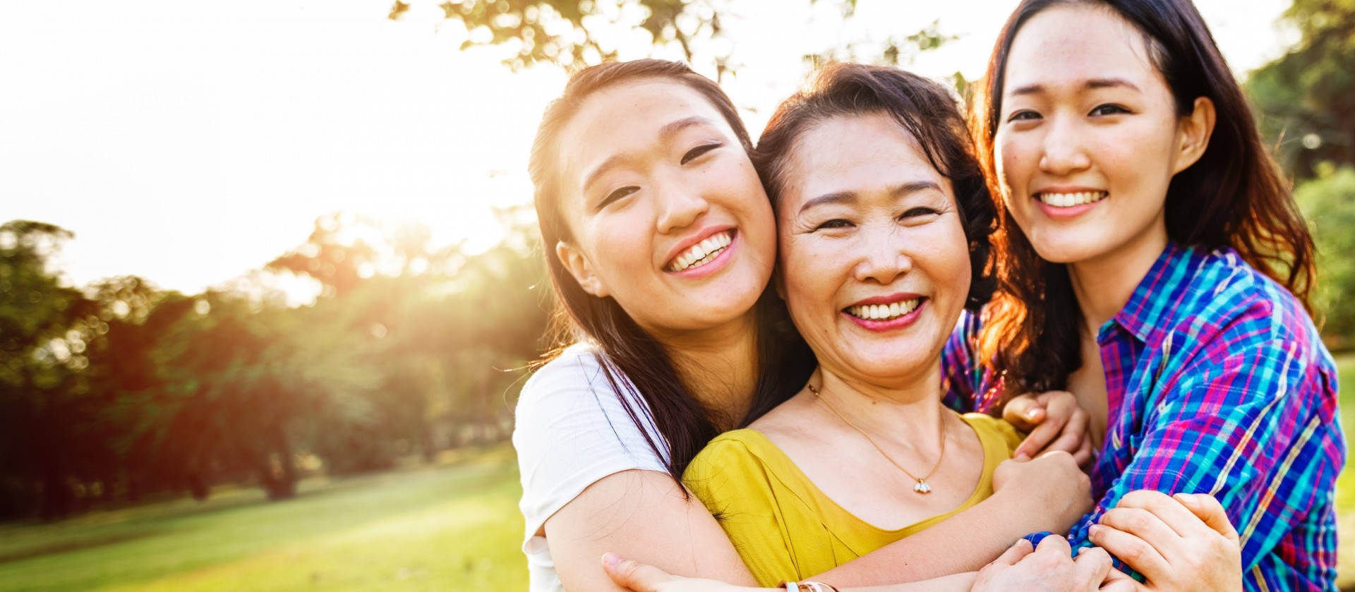 Two young adult daughters hugging their mother